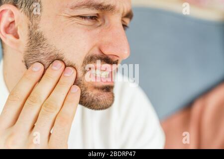 Triste maschio che soffre di un mal di denti grave Foto Stock