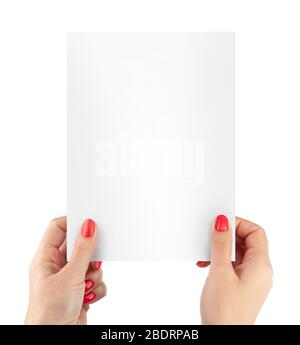 La mano di una donna taglia un foglio di carta bianca con le