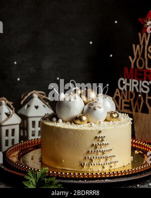 torta a tema natalizio con giocattoli di albero di natale in oro e bianco Foto Stock