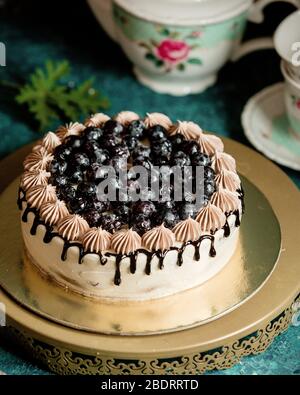 torta classica decorata con sciroppo di cioccolato e mirtilli Foto Stock