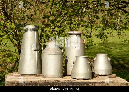 Una varietà di churns di latte usato come decorazioni su un stand di raccolta del latte fuori di una fattoria in Somerset.Frome, Regno Unito Foto Stock