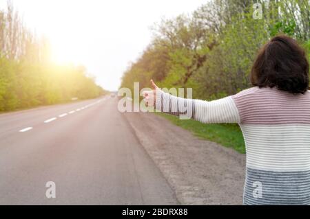 Donna hitchhiking. Vista posteriore. Foto Stock