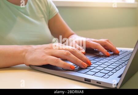 Primo piano delle mani di una donna che digita sul computer portatile. Foto Stock