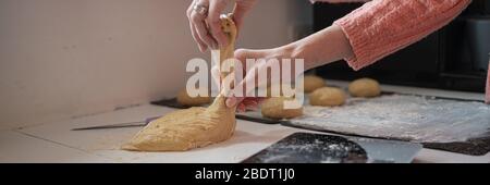 Immagine di una donna che fa palle di pasta vegana appena fatta per panini o ciambelle. Foto Stock