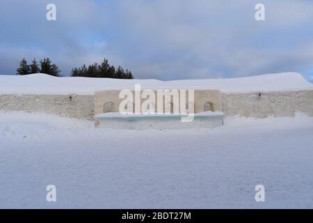 Muro ad arco e sistemazione realizzati solo da ghiaccio Remote Lappish paesaggio sopra le sfumature del cerchio artico di bianco soffice neve in polvere si incontrano cielo blu chiaro Foto Stock