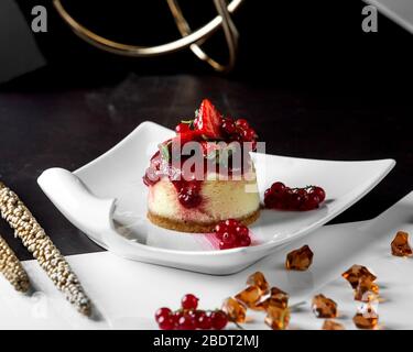 cheesecake con porzionato e ricoperta di frutti di bosco e marmellata Foto Stock