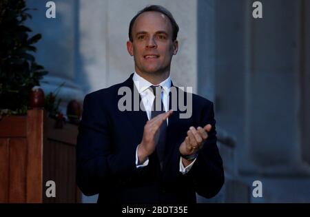 Il Segretario degli Esteri Dominic Raab si aggrappò al di fuori dell'Ufficio degli Esteri e del Commonwealth di Londra per salutare gli eroi locali durante l'iniziativa NHS di Clap for Carers del Giovedi per applaudire i lavoratori del NHS che combattono la pandemia del coronavirus. Foto Stock