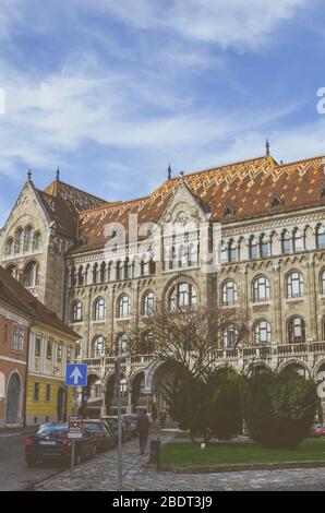 Budapest, Ungheria - 6 novembre 2019: Il bellissimo edificio storico dell'Archivio Nazionale di Ungheria nella capitale ungherese Budapest. L'esterno della casa circondata da alberi e auto. Foto Stock