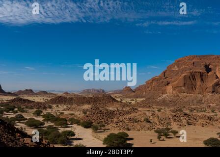 Formazioni rocciose naturali, alberi e capanna di nomade, altopiano di Ennedi nel Sahara dessert, Ciad, Africa Foto Stock