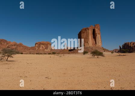 Formazione astratta di rocce a Ennedi plateau, uno in forma lira sullo sfondo, nel deserto del Sahara, Ciad, Adrica Foto Stock