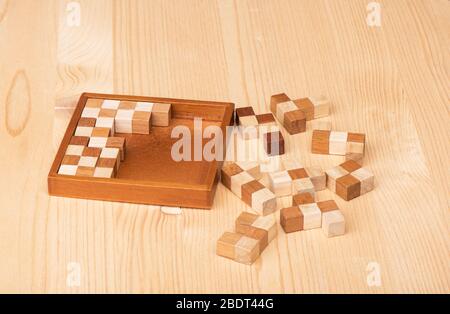 Puzzle in legno di Polymino su un tavolo di legno. Puzzle disassemblato Polymino. Concetto di puzzle. Foto Stock