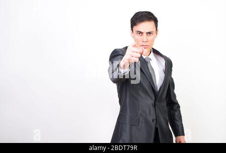 Uomo in tuta che punta davanti con un dito indice. Sfondo bianco, scatto medio Foto Stock