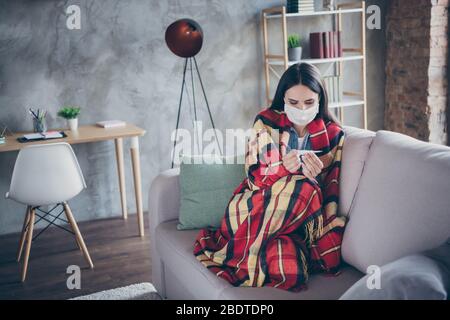 Foto di bella signora dispiaciuti soggiorno a casa da solo quarantena coperta coperta coperta a scacchi indossare maschera protettiva misurazione della temperatura seduta confortevole Foto Stock