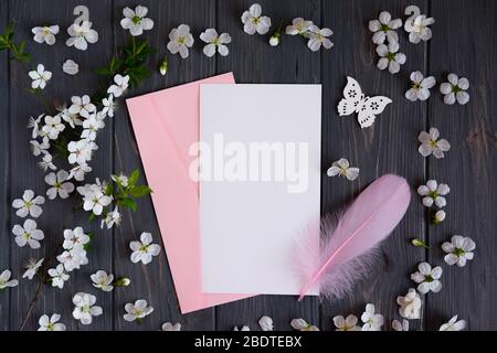 Fatti un giro con una busta postale e fiori di albicocca su uno sfondo grigio di legno. Cornice a molla per il testo. Foto Stock