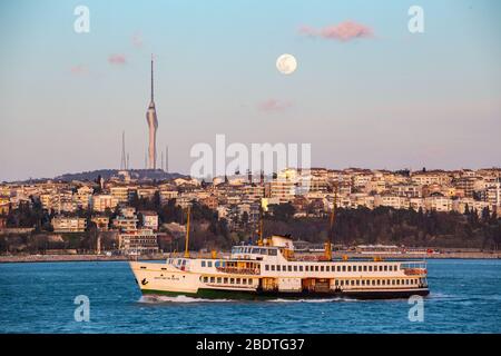 7 aprile 2020: Supermoon illumina i cieli di Istanbul il 7 aprile 2020. Una superluna è una luna piena che coincide quasi con la distanza più vicina che la Luna raggiunge la Terra nella sua orbita ellittica, con una dimensione visibile del disco lunare più grande del solito visto dalla Terra. Kucuk Camlica TV radio Tower, è una torre di telecomunicazioni in Uskudar, in primo piano. Credit: Tolga Ildun/ZUMA Wire/Alamy Live News Foto Stock