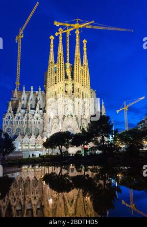 Vista notturna della basilica di la Sagra Familia riflessa nel lago della Placa de Gaudi. Foto Stock