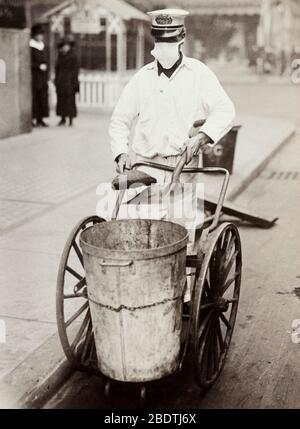 Pulitore di strada con maschera di influenza durante 1918 spagnolo influenza Pandemic Foto Stock