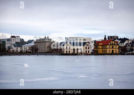 Il lago di Tjornin è congelato in inverno a Reykjavik, Islanda Foto Stock