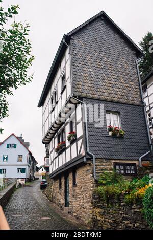 Case a graticcio lungo il fiume Ruhr a Monschau, Eifel in una giornata nuvolosa Foto Stock