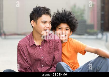 Giovani fratelli adolescenti di razza mista guardando la macchina fotografica Foto Stock