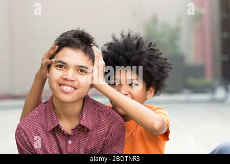 Giovani fratelli adolescenti di razza mista guardando la macchina fotografica Foto Stock