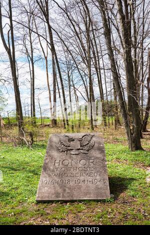 Worcester, PA - 8 aprile 2020: Questo monumento in pietra dice 'onore a coloro che hanno servito 1916-1918 1941-1945' e si trova tra i boschi vicino al gazebo in Hee Foto Stock