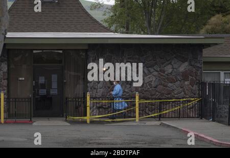 Hayward, Stati Uniti. 9 aprile 2020. Un membro dello staff si trova all'esterno del Gateway Care & Rehabilition Center, una struttura infermieristica specializzata a Hayward, California, giovedì 9 aprile 2020. Trentacinque pazienti sono risultati positivi al test COVID-19 insieme a 24 persone. Sei pazienti sono morti. Foto di Terry Schmitt/UPI Credit: UPI/Alamy Live News Foto Stock