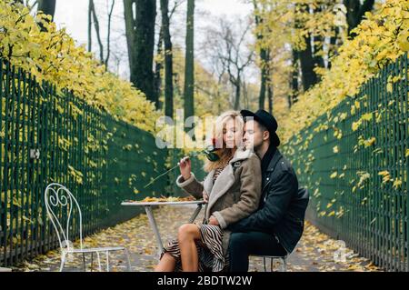 Coppia con occhi chiusi che si siiting sulla sedia al centro del passaggio e abbracciando Foto Stock