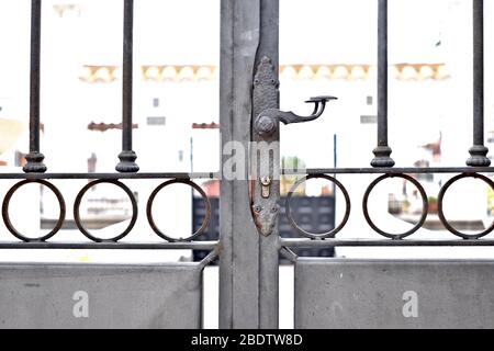 Cancello in acciaio forgiato con barre, maniglia e serratura, chiuso, ingresso ad una vecchia villa classica mediterranea. Foto Stock