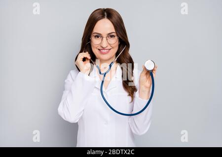 Ritratto di lei bella allegra felice sicuro ondulato-capelli doc esame cliente paziente centro diagnostico clinica ascolto battito cardiaco isolato Foto Stock