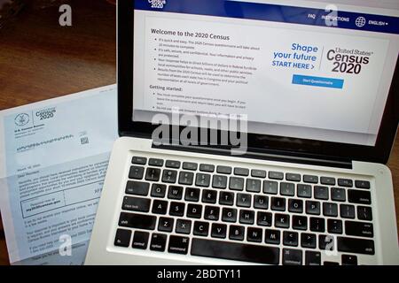 Stati Uniti 2020 Census moduli, lettera, cartolina e pagina web sullo schermo di un notebook Foto Stock