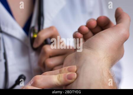 Infermiere che prende il polso del paziente. Può essere un medico, un medico curante, un infermiere o un farmacista. Assistenza medica professionale per il paziente da vicino Foto Stock