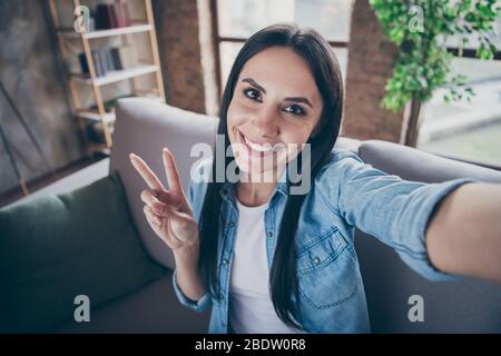 Autoritratto di lei bella bella bella bella bella bella ragazza allegra bruna allegra mostrando v-segno tempo libero trascorrere tempo libero rimanendo a casa Foto Stock