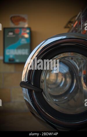 Compositionally buona foto di più aprire porte tondi Chrome di essiccatori in Laundromat con Blue e Green Change Sign in Behind Foto Stock