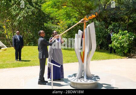 (200410) -- PECHINO, 10 aprile 2020 (Xinhua) -- il presidente ruandese Paul Kagame e la prima signora Jeannette Kagame illuminano una fiamma di ricordo al Kigali Genocide Memorial, il luogo di riposo finale per oltre 250,000 vittime del genocidio del 1994 contro i tutsi, a Kigali, capitale del Ruanda, il 7 aprile 2020. (Memoriale del genocidio di Kigali/Handout via Xinhua) Foto Stock