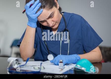 Ha lavorato troppo il medico frustrato nel suo ufficio durante la pandemia covid-19 Foto Stock