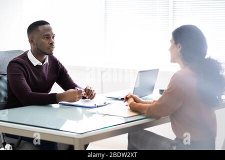 Due uomini d'affari che parlano tra loro in Office Foto Stock