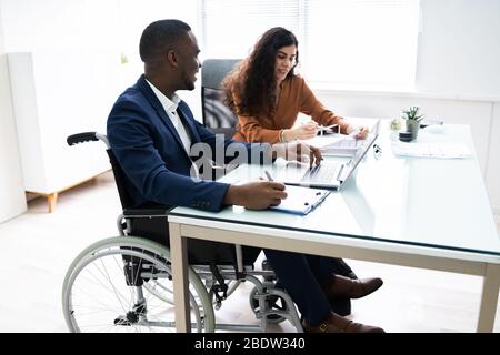 Due giovani imprenditori lavora su computer portatile al lavoro Foto Stock
