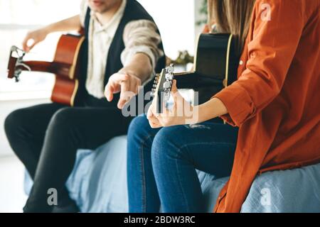 Imparare a suonare la chitarra. L'insegnante spiega allo studente le basi per suonare la chitarra. Lezioni individuali di scuola domestica o extracurricolare. Foto Stock