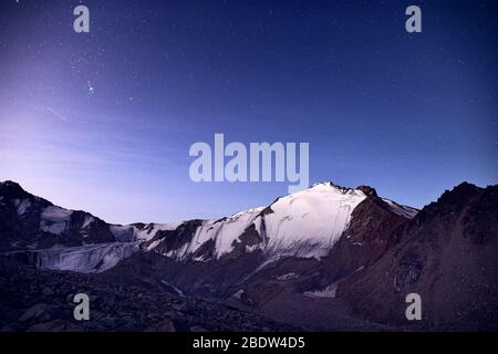 Montagne innevate sotto la notte blu cielo pieno di stelle in Kazakistan Foto Stock
