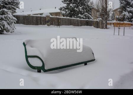 Panca del Parco coperta di neve in una giornata fredda Foto Stock