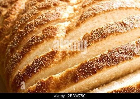 Fette di pane. Closeup estremo di pane bianco appena sfornato a fette di paese con una crosta croccante per l'uso come sfondo da forno. Foto Stock