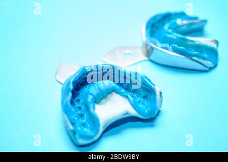 Due impronte dentali su sfondo blu con spazio per le copie. Stampi dentali dalle ganasce superiore e inferiore in materiale siliconico. Foto Stock