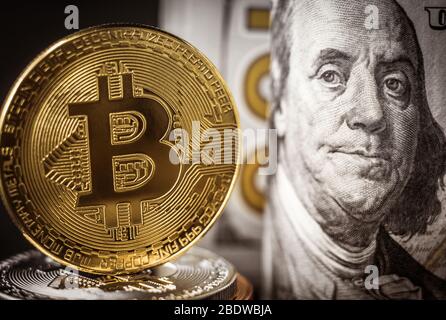 Moneta bitcoin d'oro davanti alle banconote in dollari. Nuovo concetto di denaro virtuale Foto Stock