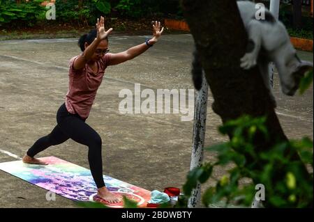 Giacarta, Indonesia. 10 aprile 2020. Una donna pratica lo yoga in un campo aperto il primo giorno di restrizioni sociali su larga scala a Jakarta, Indonesia, 10 aprile 2020. Nella lotta contro la pandemia COVID-19, il governo ha adottato misure aggressive per rispondere alla rapida diffusione del virus. Tra le misure previste vi sono le politiche per applicare lo status di emergenza nazionale in tutto il paese, una restrizione sociale su larga scala nella capitale del paese di Giacarta, iniziata venerdì 10 aprile, e una misura di distanza fisica. Credit: Agung Kuncashya B./Xinhua/Alamy Live News Foto Stock