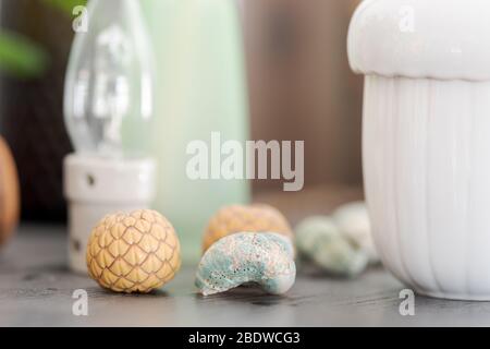 Primo piano di diversi oggetti decorativi del soggiorno su credenza di legno nero polveroso, lampadina, conchiglie marine e ciotola bianca Foto Stock