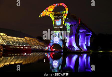 La locale Falkirk TapestryAV in collaborazione con il progetto canali scozzesi un messaggio di ringraziamento del NHS sulla Falkirk Wheel, il primo e unico sollevatore a rotazione al mondo, Progettato e costruito per collegare il Forth & Clyde Canal e il canale Union come il Regno Unito continua in blocco per contribuire a frenare la diffusione del coronavirus. Foto Stock