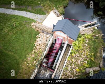 Un sistema di idroalimentazione a testa bassa a vite di Archimedes installato da Hallidays Hydropower per alimentare un edificio di mulino riutilizzato a Manchester, Regno Unito Foto Stock