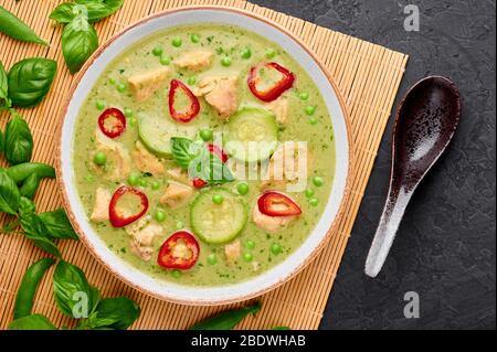 Thai verde curry con pollo o Gaeng Kaew WAN Gai in ciotola bianca su sfondo nero ardesia. Il Tailandese Green Curry e' un piatto di cucina Thailandese con cucina CH verde Foto Stock