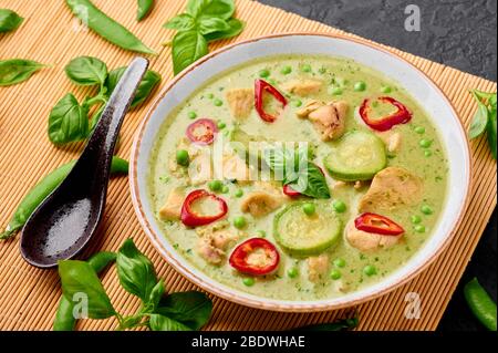 Thai verde curry con pollo o Gaeng Kaew WAN Gai in ciotola bianca su sfondo nero ardesia. Il Tailandese Green Curry e' un piatto di cucina Thailandese con cucina CH verde Foto Stock